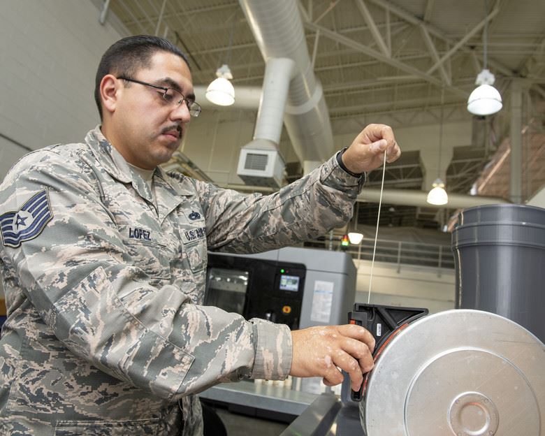  Tech. Sgt. Rogelio Lopez, 60th Maintenance Squadron assistant aircraft metals technology section chief, loads Ultem 9085 material into a canister for use in the Stratasys F900 3D printer, Aug. 15, 2019, Travis Air Force Base, Calif. [Image: U.S. Air Force photo by Louis Briscese] 