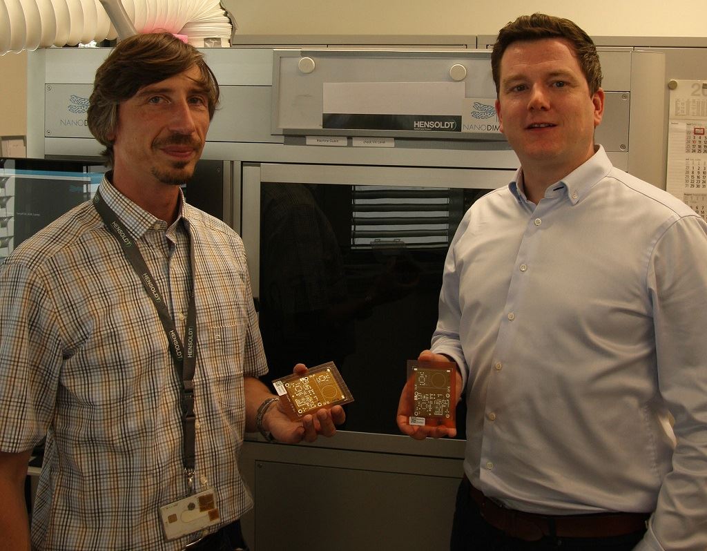  HENSOLDT ALM project manager Andreas Salomon (left) and Nano Dimension’s Director Sales EMEA Valentin Storz with first PCB output. [Image: Nano Dimension] 