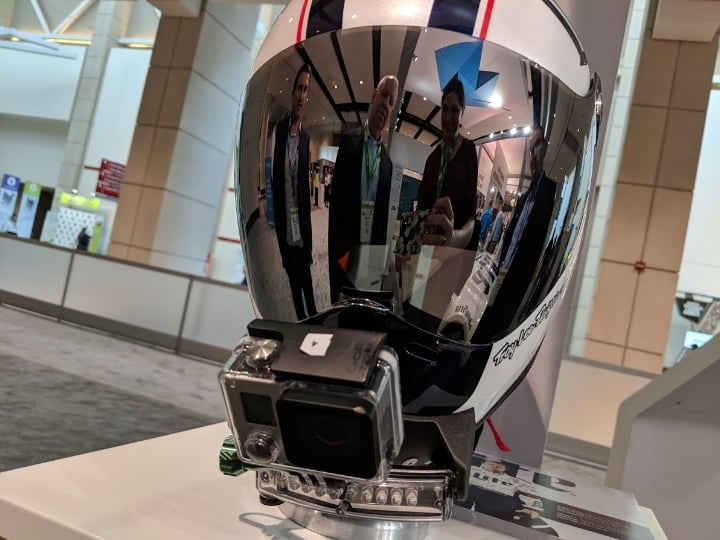  Reflected in the helmet, Rich Garrity, President, Americas (left) and Pat Carey, SVP, Sales (middle) show me (right) a custom-made GoPro mount 3D printed for Team Penske as an example of customized device holding capabilities with carbon fiber materials 