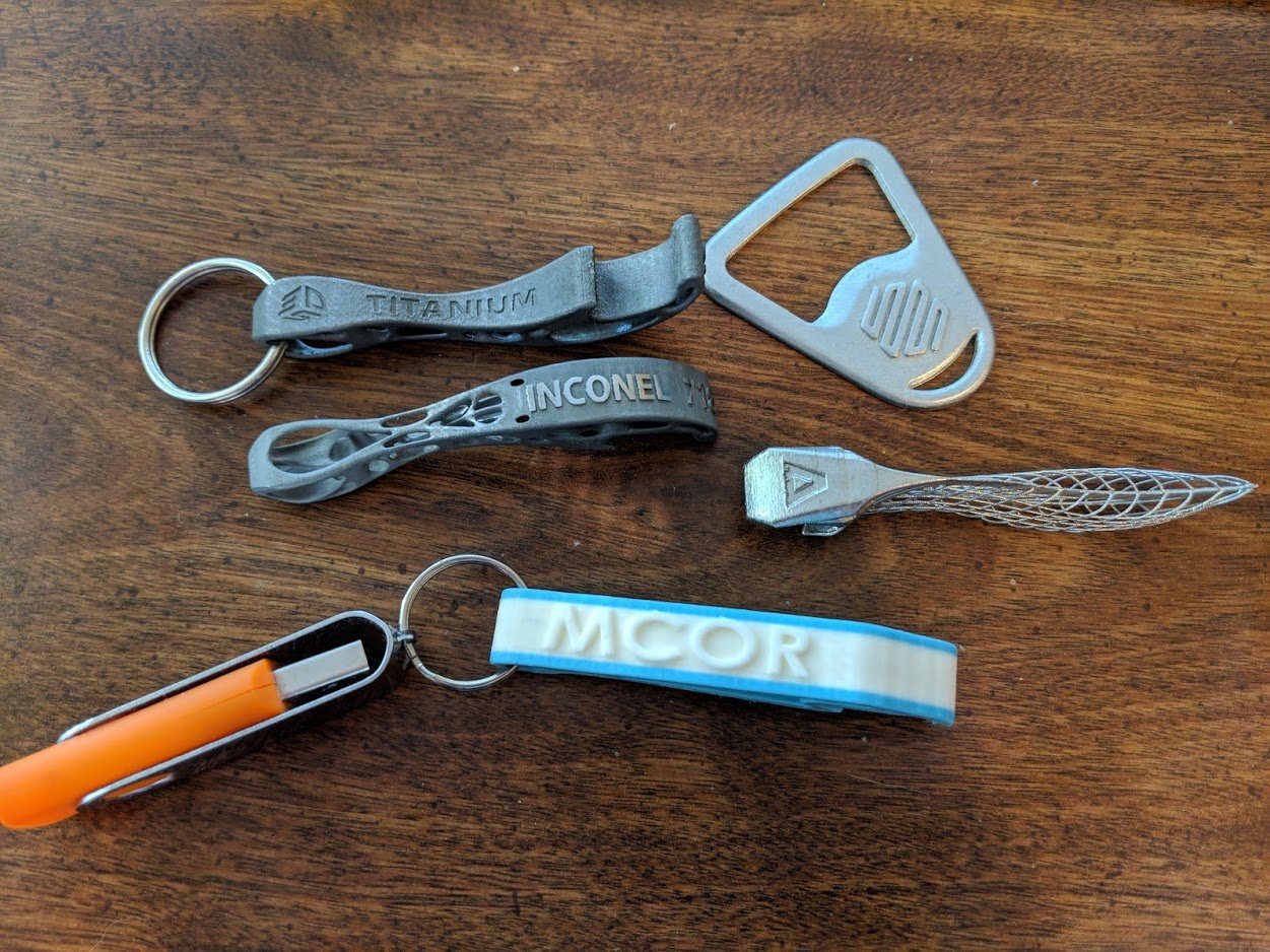  Clockwise from top right: Markforged, Velo3D, Mcor, 3D Systems (Inconel 718), 3D Systems (titanium) 3D printed bottle openers 