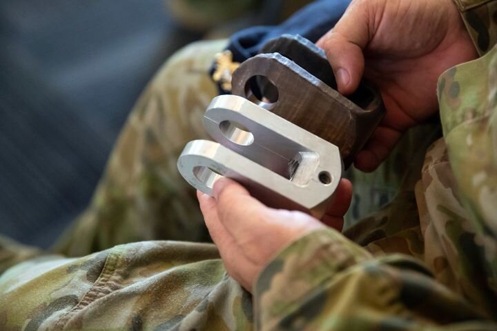  Australian soldiers inspect a 3D printed metal part [Source: SPEE3D] 