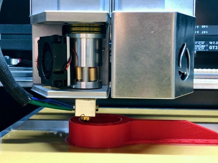  Unique revolving extruder with cover off on the FL300 3D printer. If you look closely you can see two of the three threaded rods around the filament. [Source: Fabbaloo] 