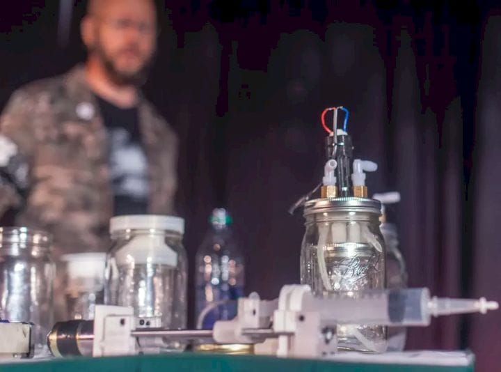  Michael Laufer (in the background) pictured with his Apothecary MicroLab. Laufer says that he has synthesized five different pharmaceutical drugs using his lab. (Image courtesy of Seth Rosenblatt, The Parallax.) 