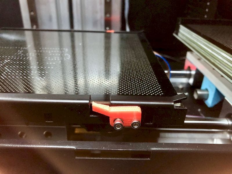  The Tiertime X5 continuous 3D printer has a supply of print plates on the right, and they slide into the frame on the left for leveling 