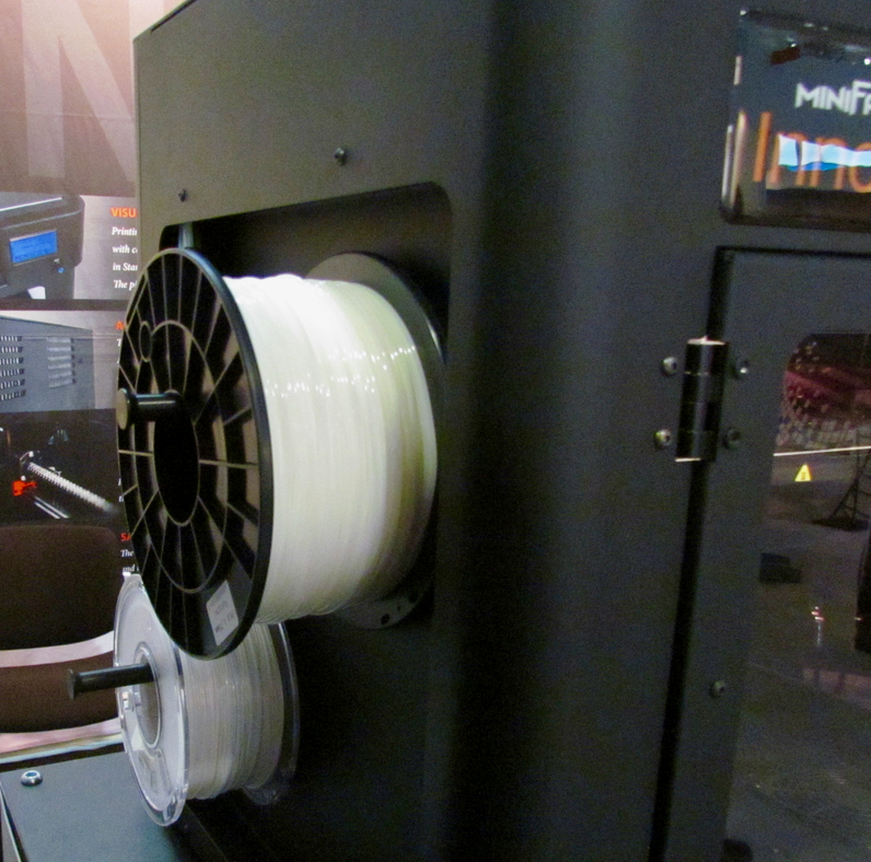  Filament spools are mounted on the exterior of the Minifactory desktop 3D printer 