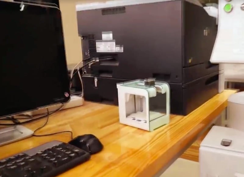  The PocketMaker desktop 3D printer beside typical office equipment 