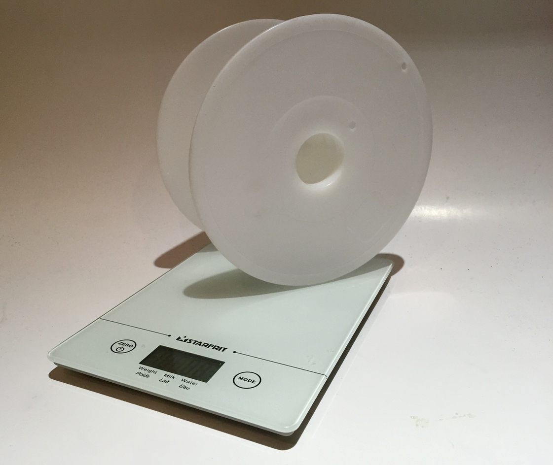  A digital scale weighs an empty 3D print spool 