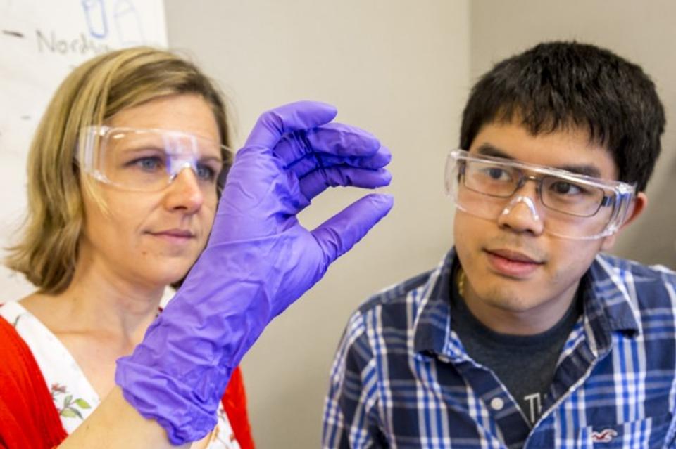  LLNL researchers checking out a 3D printed glass lens 